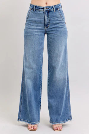 Judy Blue Retro HW Wide Fit Jeans in blue with raw hem and stretchy fit. Available in sizes 24-32.