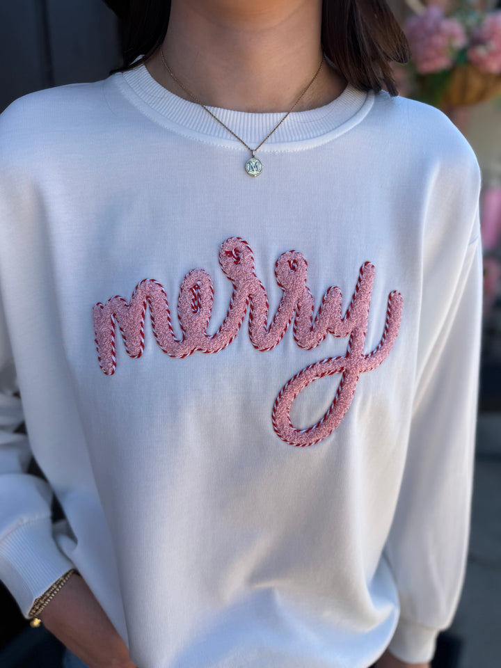 White Sarah Merry Boucle Sweatshirt with textured pink and red “merry” embroidery. Available in all sizes.