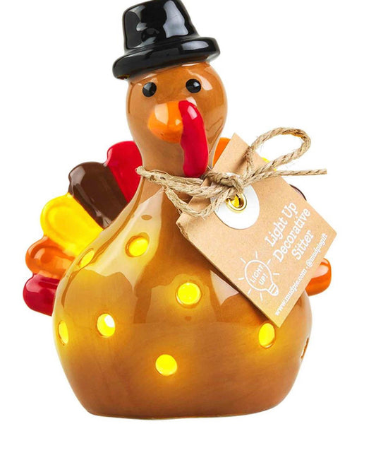 Hand-painted ceramic turkey with black hat, colorful tail, yellow LED lights. Available in small and large sizes.