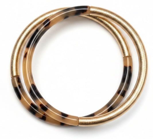 Two intertwined circular bands form the Leo Tortoise and Gold Bracelet: one with a textured gold finish, the other in brown and black tortoise shell pattern. Available in small, medium, and large sizes.