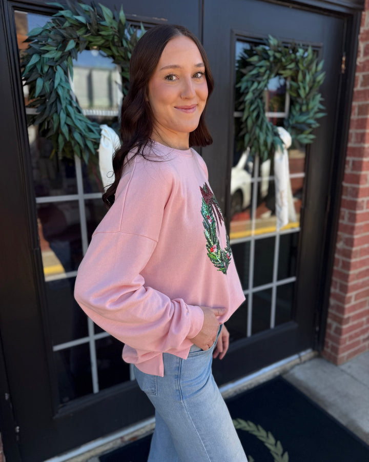 Clara Wreath Sequin Sweatshirt in light pink with sequined chest wreath and side-slit hem. Available in multiple sizes.