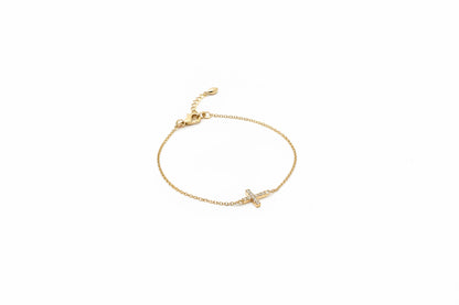 Slim chain bracelet with horizontal crystal-studded cross charm and adjustable clasp. Available in various sizes.