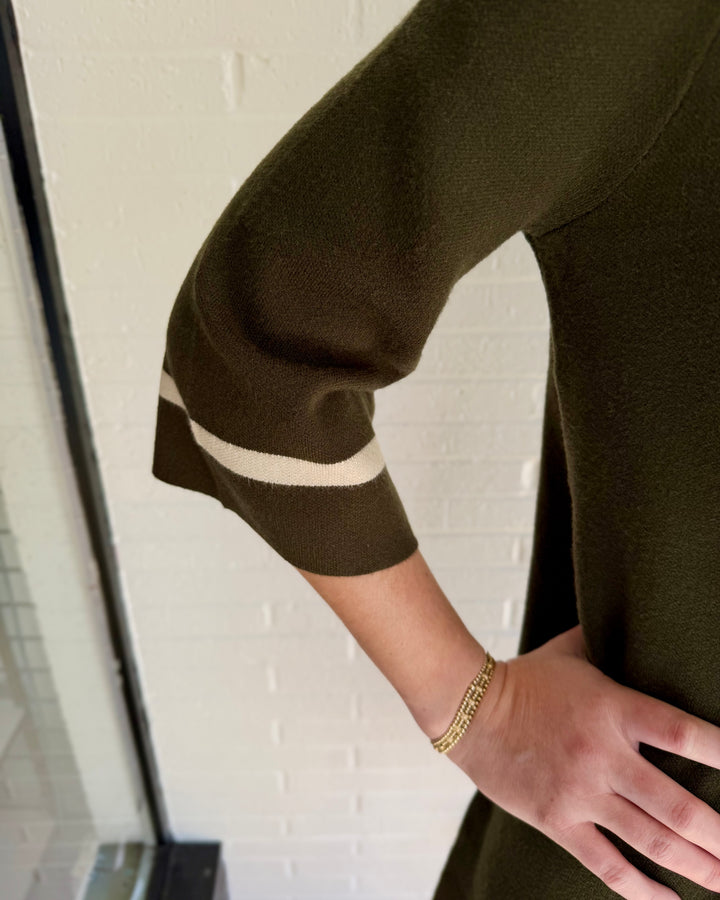 Olive green mock neck contrast trim sweater dress with elbow-length sleeves and cream cuff stripes. Available in all sizes.