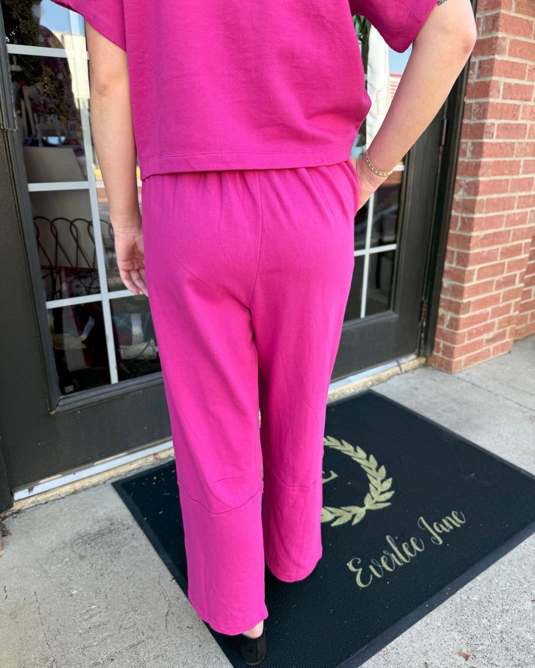 Fuchsia barrel-leg knit pants with a high drawstring waistband. Available in all sizes.