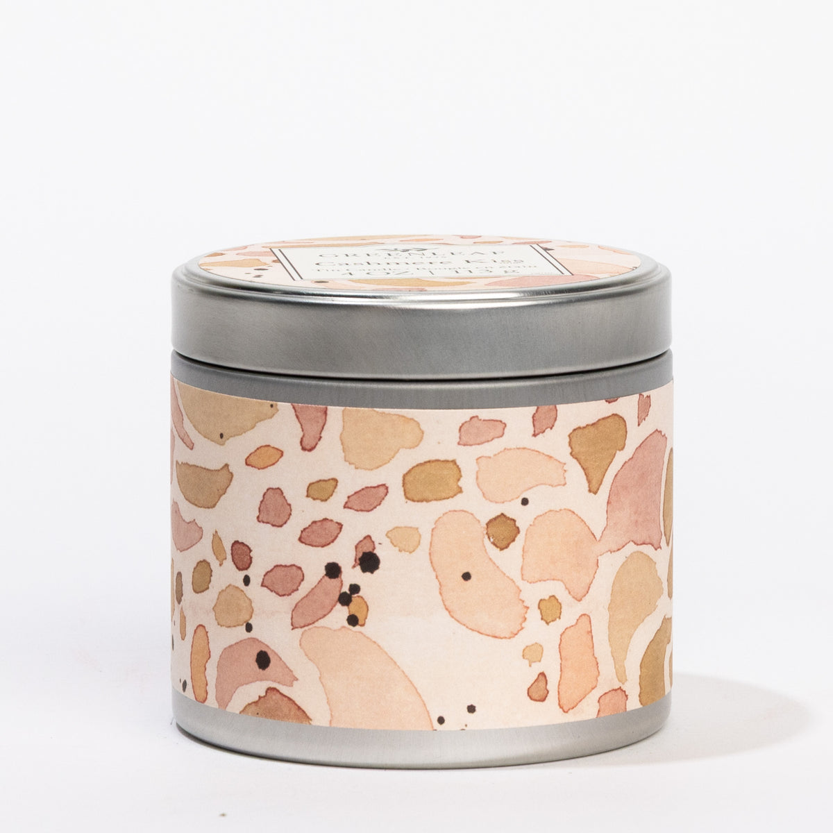 Cashmere Kiss 4 oz. round silver tin candle with a peach terrazzo label and "GREENLEAF Cashmere Kiss" on the lid.