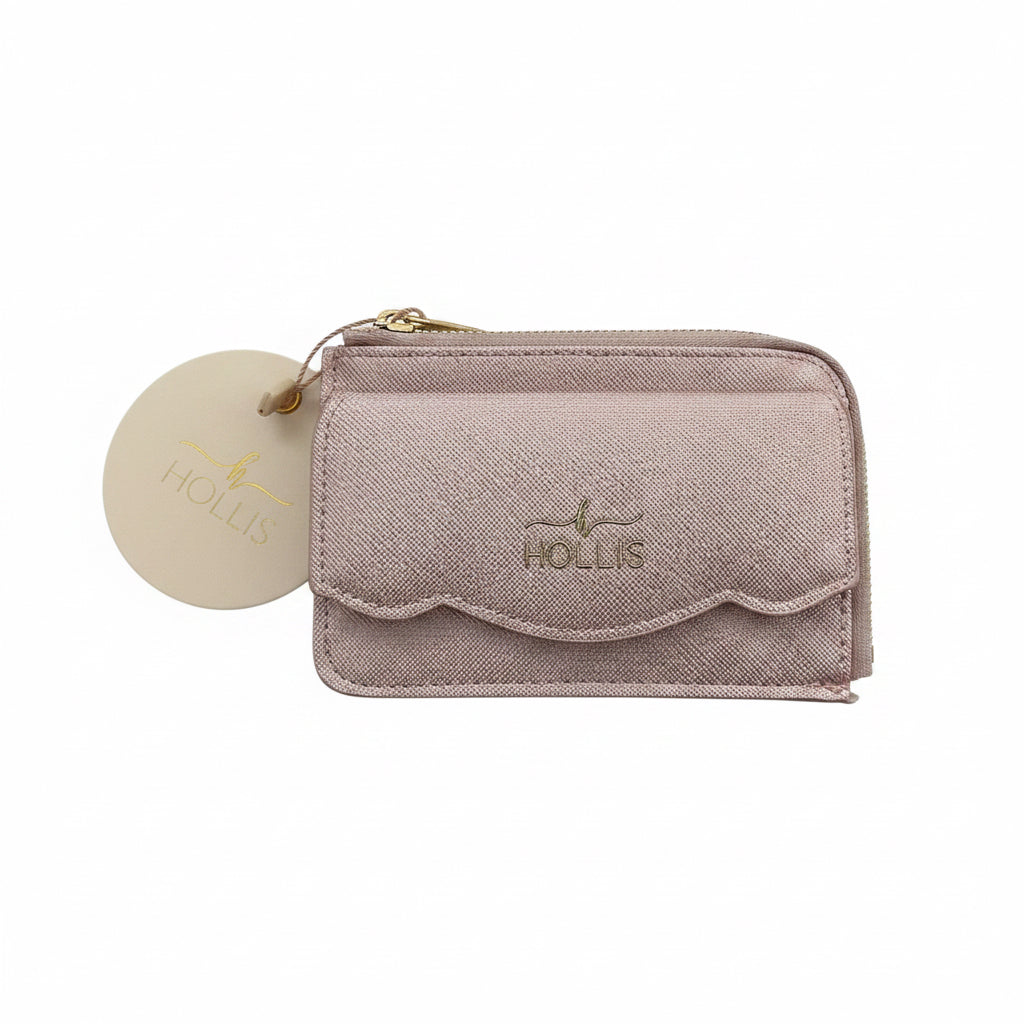 Small light pink zippered cardholder with a scalloped front pocket, gold “HOLLIS” logo, and round cream tag on zipper pull. Sizes available: not specified.
