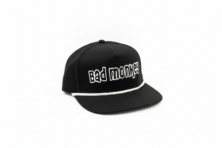 Black adjustable "Bad Monkey" hat with white rope above brim; bold white front lettering. Available in one size fits most.