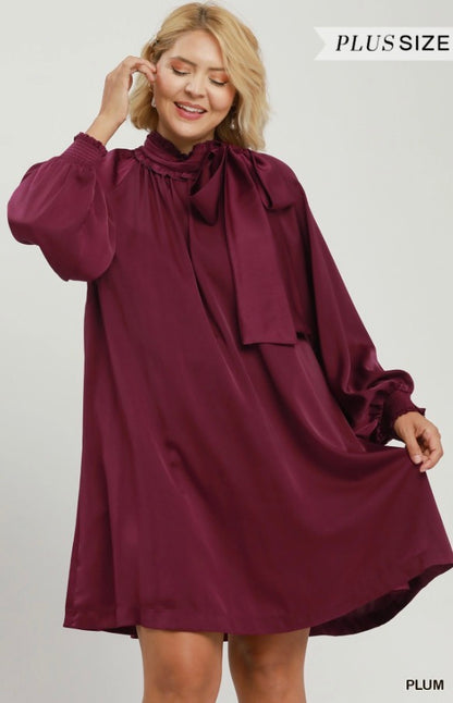 Plus-size Satin Tie Neck Dress in plum with long sleeves and a neckline bow; available in sizes 1X-4X.