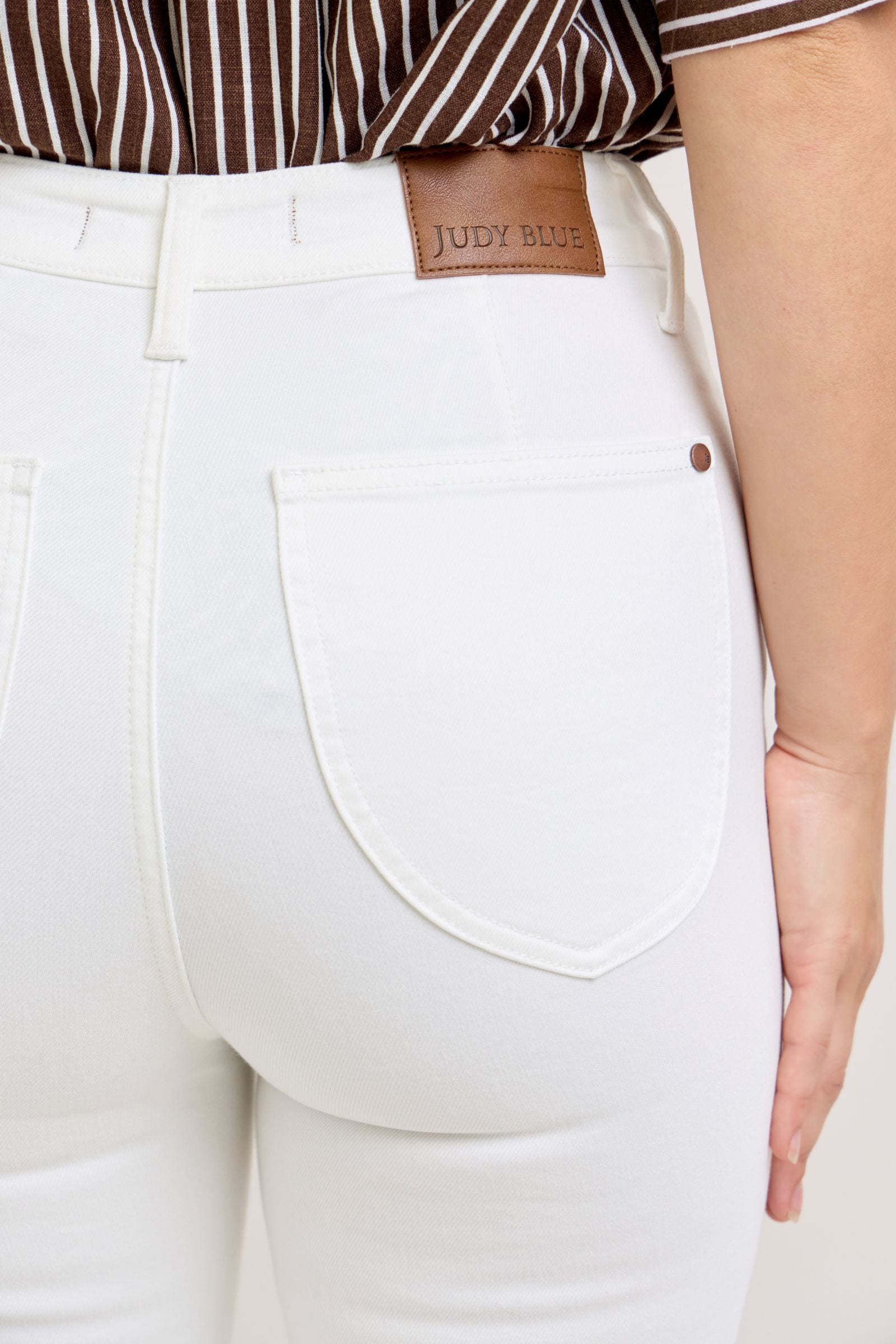 Judy Blue White Capri Jeans with large back pockets and brown leather patch. Available in sizes 2-16.