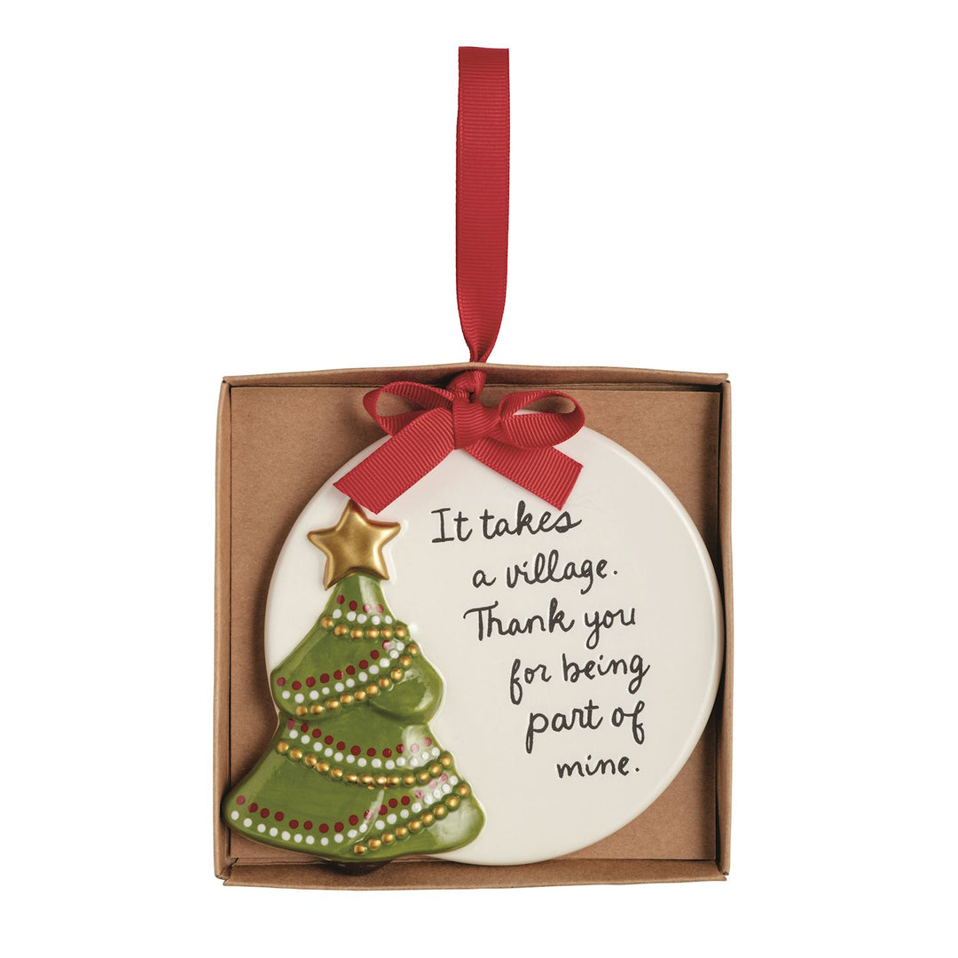 Round hand-painted ceramic Thank You ornament featuring a green Christmas tree with a gold star and the text, “It takes a village. Thank you for being part of mine.”