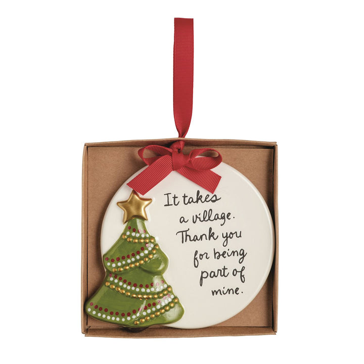 Round hand-painted ceramic Thank You ornament featuring a green Christmas tree with a gold star and the text, “It takes a village. Thank you for being part of mine.”
