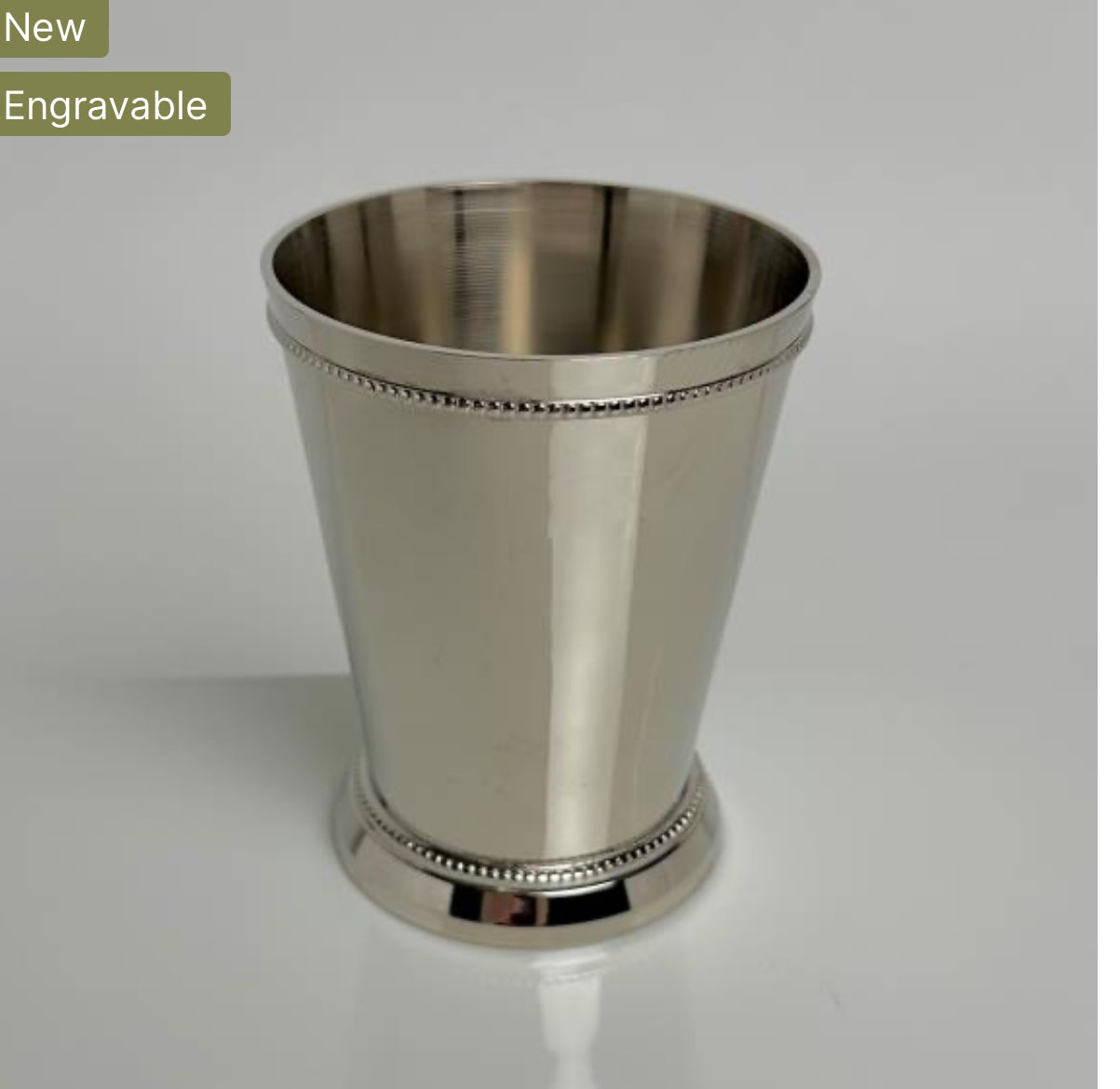 A Classic Nickle Mint Julep Cup, shining in silver with a slightly tapered design and beaded decorative rims on both top and bottom edges. Sizes available: 8oz, 12oz. New. Engravable.