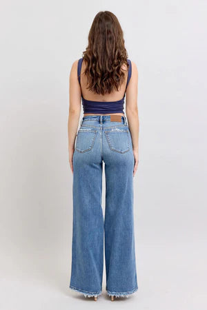 Judy Blue Retro HW Wide Fit Jeans: high-waisted, wide-leg, raw hem, stretchy. Available in sizes 24–32.
