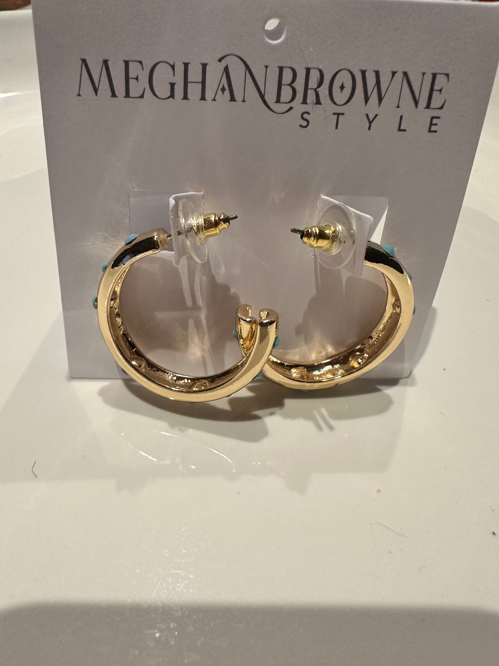 Small, shiny gold Romy Hoop Earrings with a thick, irregular design and clear backings. Sizes available: small.