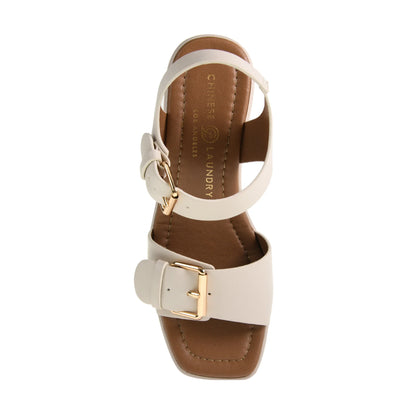 The Drew Platform Sandal in Cream features a square toe and dual straps with adjustable gold buckles. Available sizes: 5-11.