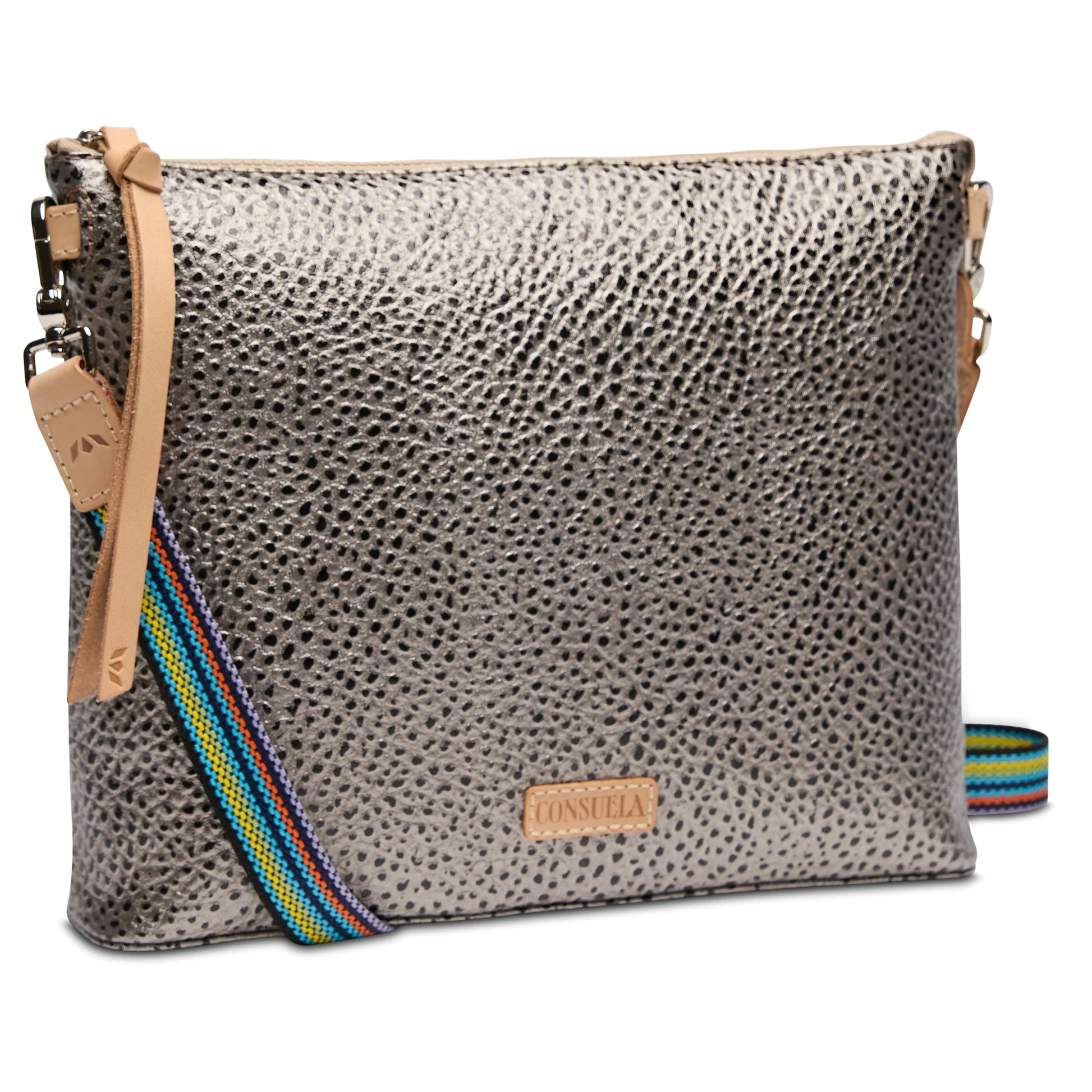 The Downtown Crossbody, Tommy has a metallic textured finish, colorful striped adjustable strap, tan leather accents, and a small front "Consuela" logo patch. Available in one size.
