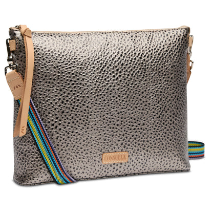 The Downtown Crossbody, Tommy has a metallic textured finish, colorful striped adjustable strap, tan leather accents, and a small front "Consuela" logo patch. Available in one size.