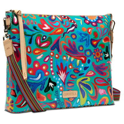 Downtown Crossbody Tasha: rectangular bag in durable ConsuelaCloth with vibrant floral and abstract pattern, tan leather accents, multicolored adjustable strap, and front “Consuela” label. Available sizes: standard.