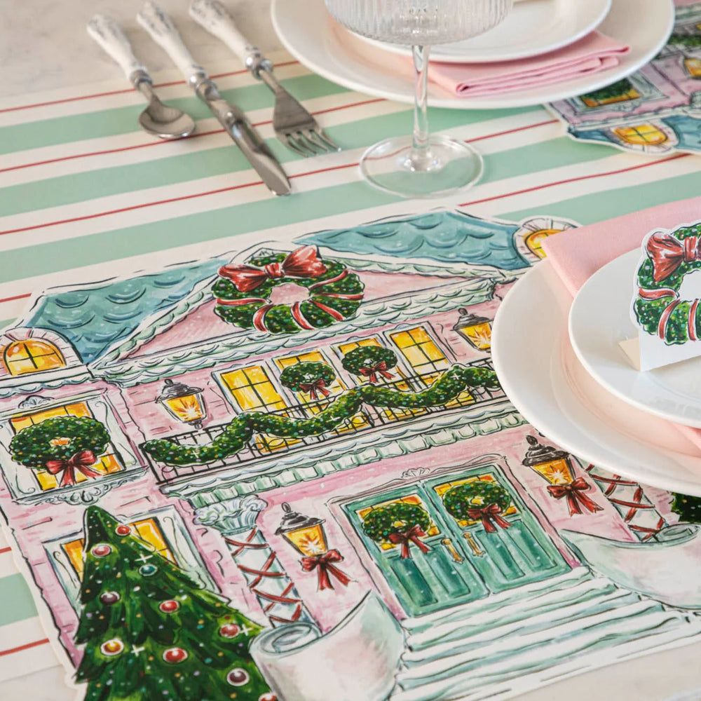 Holiday Home Placemats featuring a pink house with wreaths, garlands, and a tree.