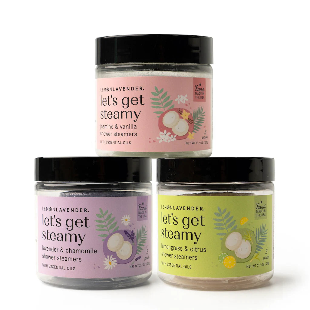 Three jars of Let’s Get Steamy Shower Steamers in Lemon Lavender, in pink, purple, and yellow. Size options available.