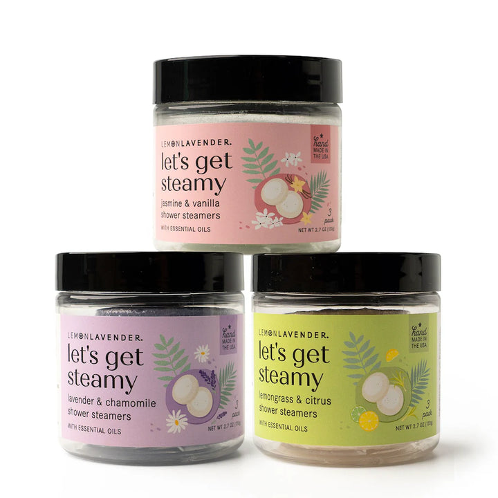 Three jars of Let’s Get Steamy Shower Steamers in Lemon Lavender, in pink, purple, and yellow. Size options available.