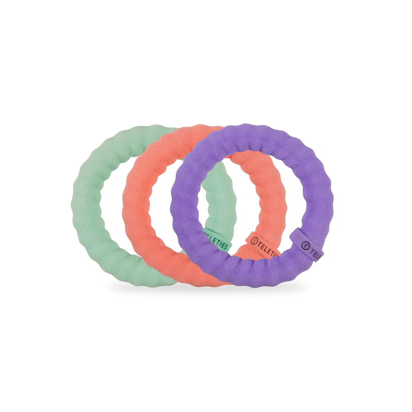 Three Teleties nylon hair ties in pastel green, coral, and purple. Available in small, medium, and large sizes.