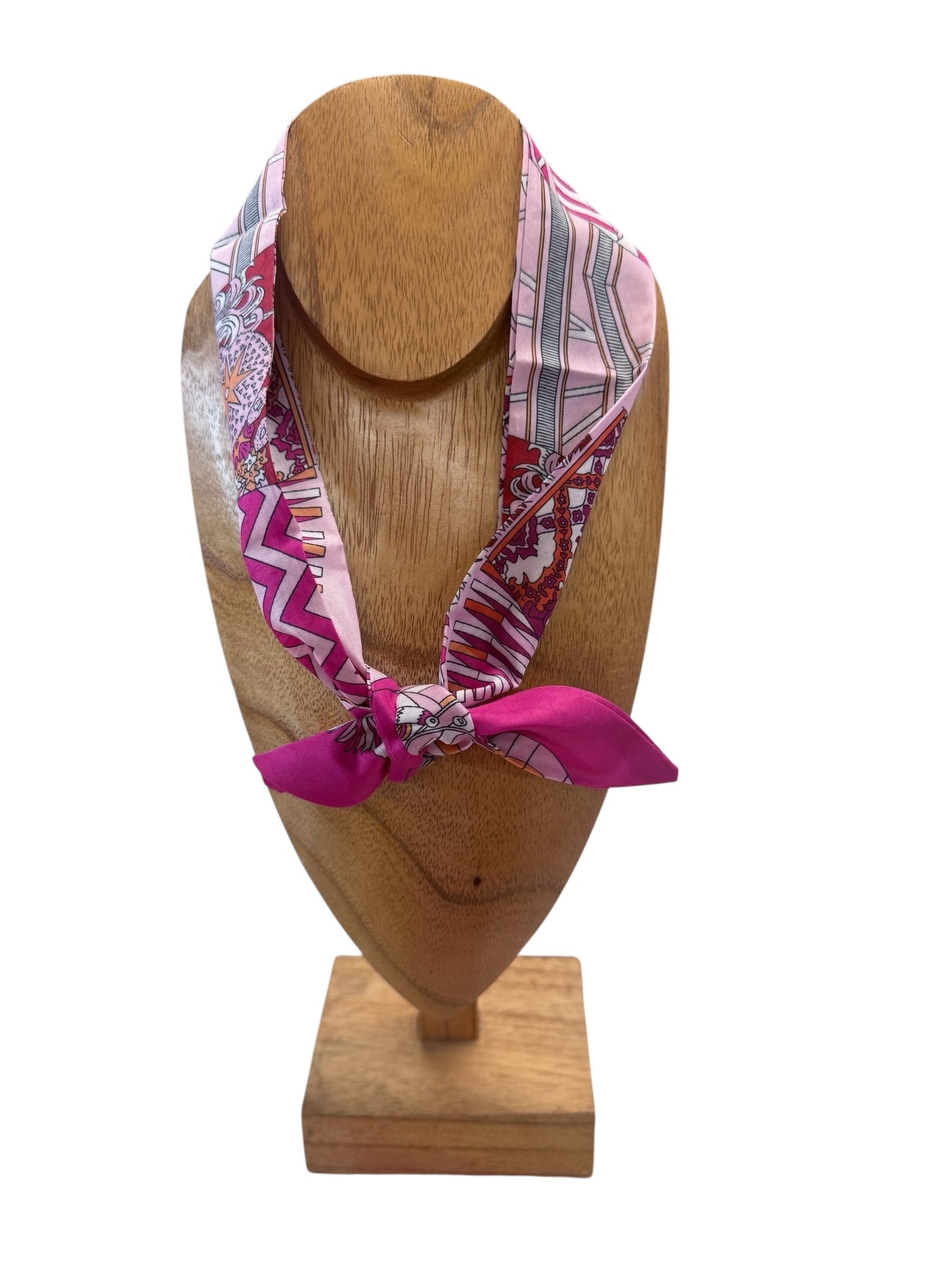 Pink patterned silk scarf necklace knotted at front; available in small, medium, and large sizes.