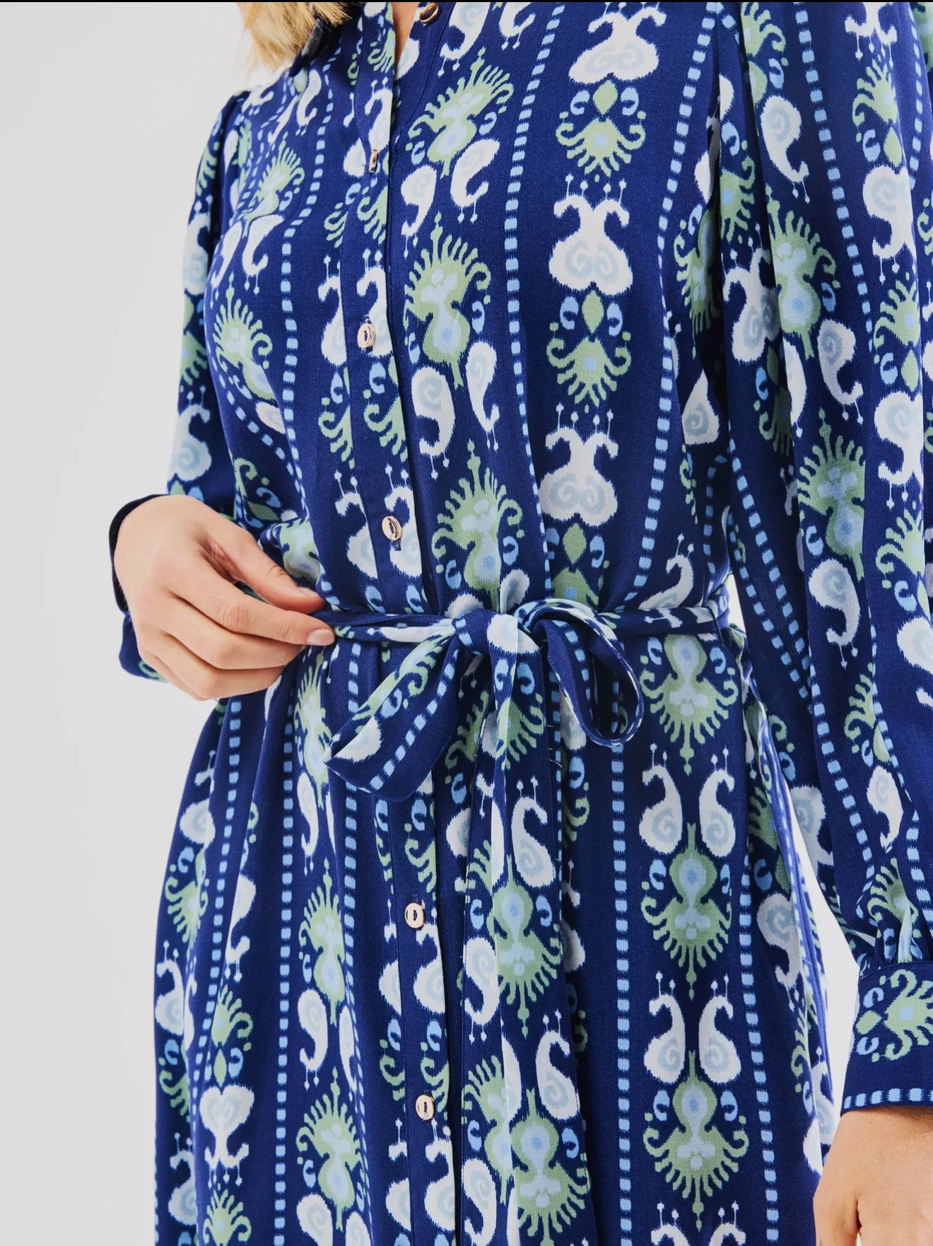 Blue Ava Ikat Stripe Dress with white and green patterns, puff long sleeves, front buttons. Available in sizes XS-XL.