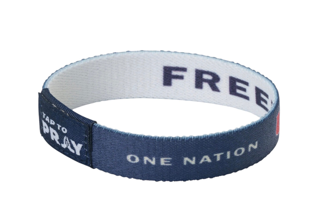Navy blue Tap To Pray™ Freedom wristbands with “ONE NATION” and “TAP TO PRAY” on the outside and “FREE” on the inside. Available in various sizes.