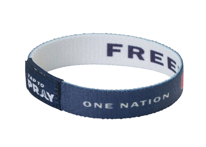 Navy blue Tap To Pray™ Freedom wristbands with “ONE NATION” and “TAP TO PRAY” on the outside and “FREE” on the inside. Available in various sizes.