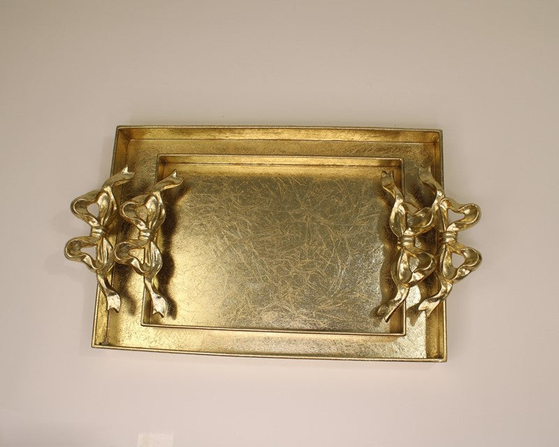 Rectangular metallic gold tray with ornate bow handles, textured surface. Available in small and large sizes.