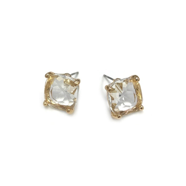 The Uma Earrings feature clear, cushion-cut gemstones in gold-tone bezels with silver posts. Available in one size.