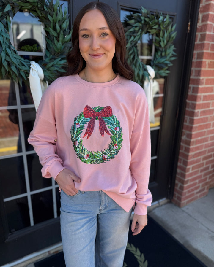 Pink Clara Wreath Sequin Sweatshirt with holiday wreath and red bow design. Available in all sizes.