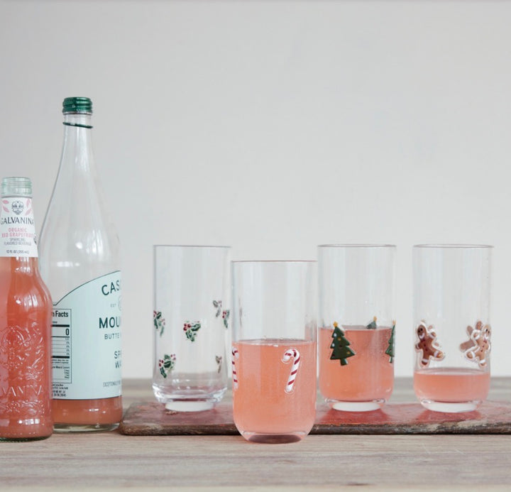 Four 18oz holiday-themed acrylic drinking glasses featuring holly, candy canes, Christmas trees, and gingerbread men.