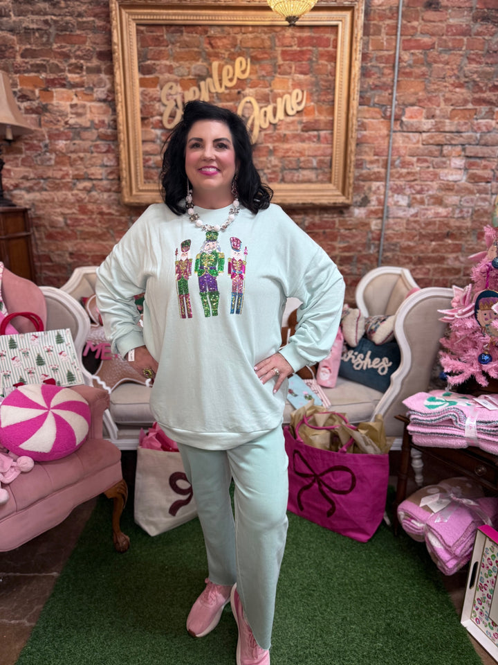 Light green Candy Nutcracker sequin sweatshirt featuring three sequined nutcrackers. Available in all sizes.