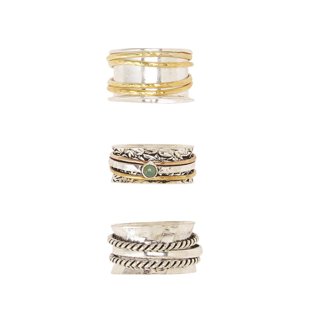 Three silver rotating rings: gold accents, textured details, green stone. Unique designs. Available in sizes 6-10.