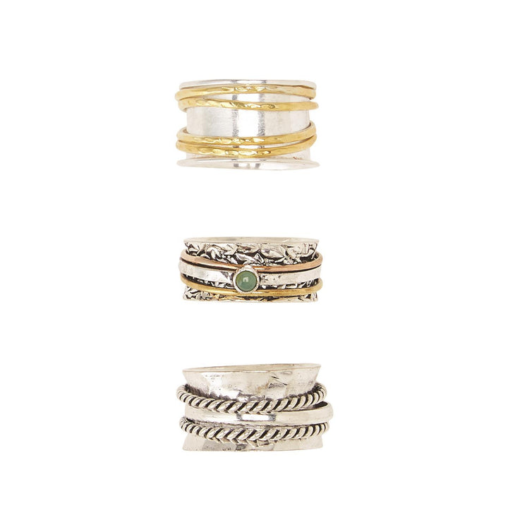 Three silver rotating rings: gold accents, textured details, green stone. Unique designs. Available in sizes 6-10.