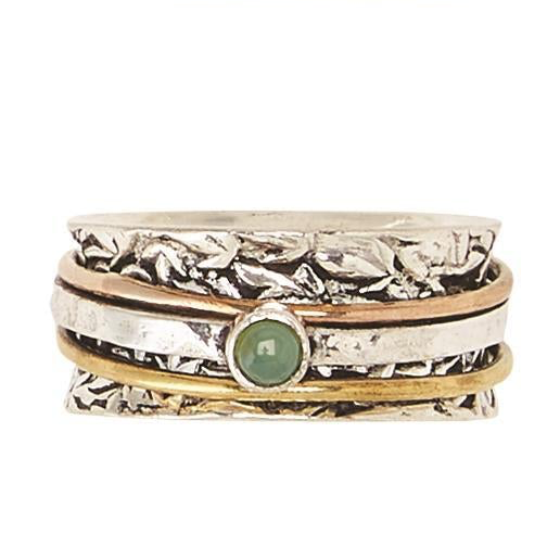 Layered silver, gold, and copper rings with a green gemstone center; available in sizes 6–10; designed for stress relief.