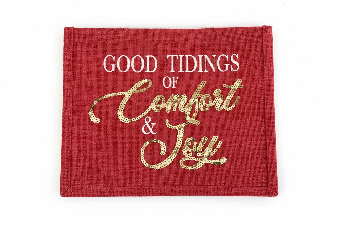 Comfort &amp; Joy Sequin Gift Tote: a red holiday tote with white text reading “GOOD TIDINGS OF” above gold sequin script reading “Comfort &amp; Joy”.