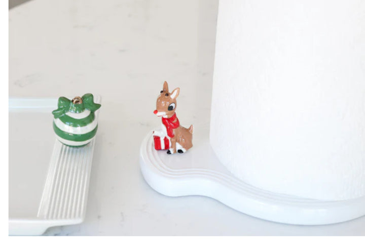 Paper Towel Holder Pinstripes: Festive reindeer figure with red scarf, holding a gift; unique wave shape design. Available size: One size.

Nora Fleming Melamine Tray: Adorned with green and white striped ornament, finished with a gold bow. Available size: One size.