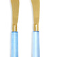 Two Blue Skies Spreaders with gold blades and glossy light blue handles. Available sizes: 5", 6", and 7".