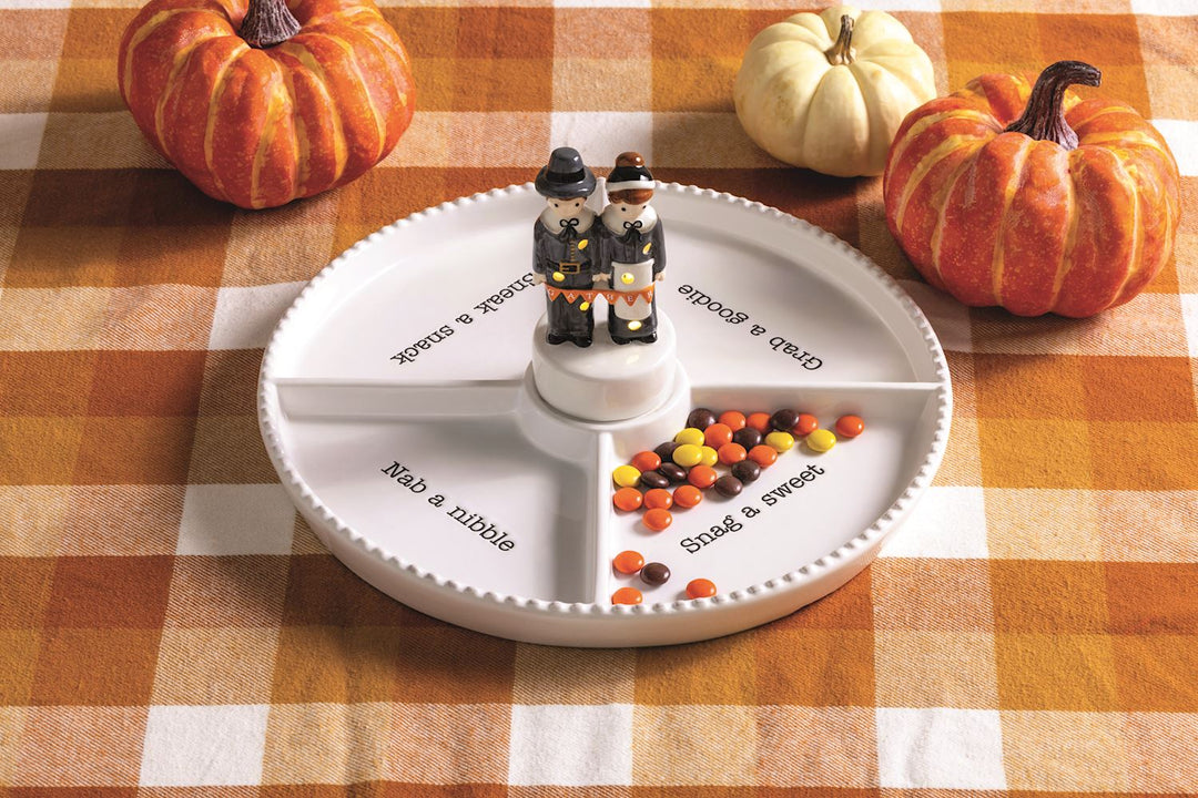 The Pilgrim LED Sitter is a white divided tray labeled “Grab a Snack,” “Grab a Goodie,” “Snag a Sweet,” and “Nibble a Nibble.” It features ceramic Pilgrim figurines. Available in small, medium, and large sizes.