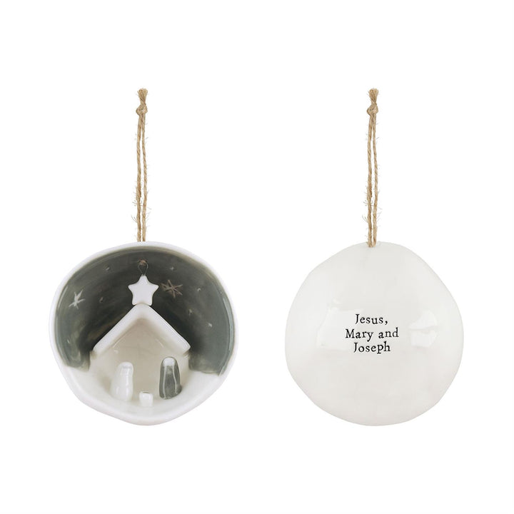 Nativity Half-Circle Porcelain Ornament in gift box, featuring a nativity scene, “Jesus, Mary and Joseph” text, and twine loop.