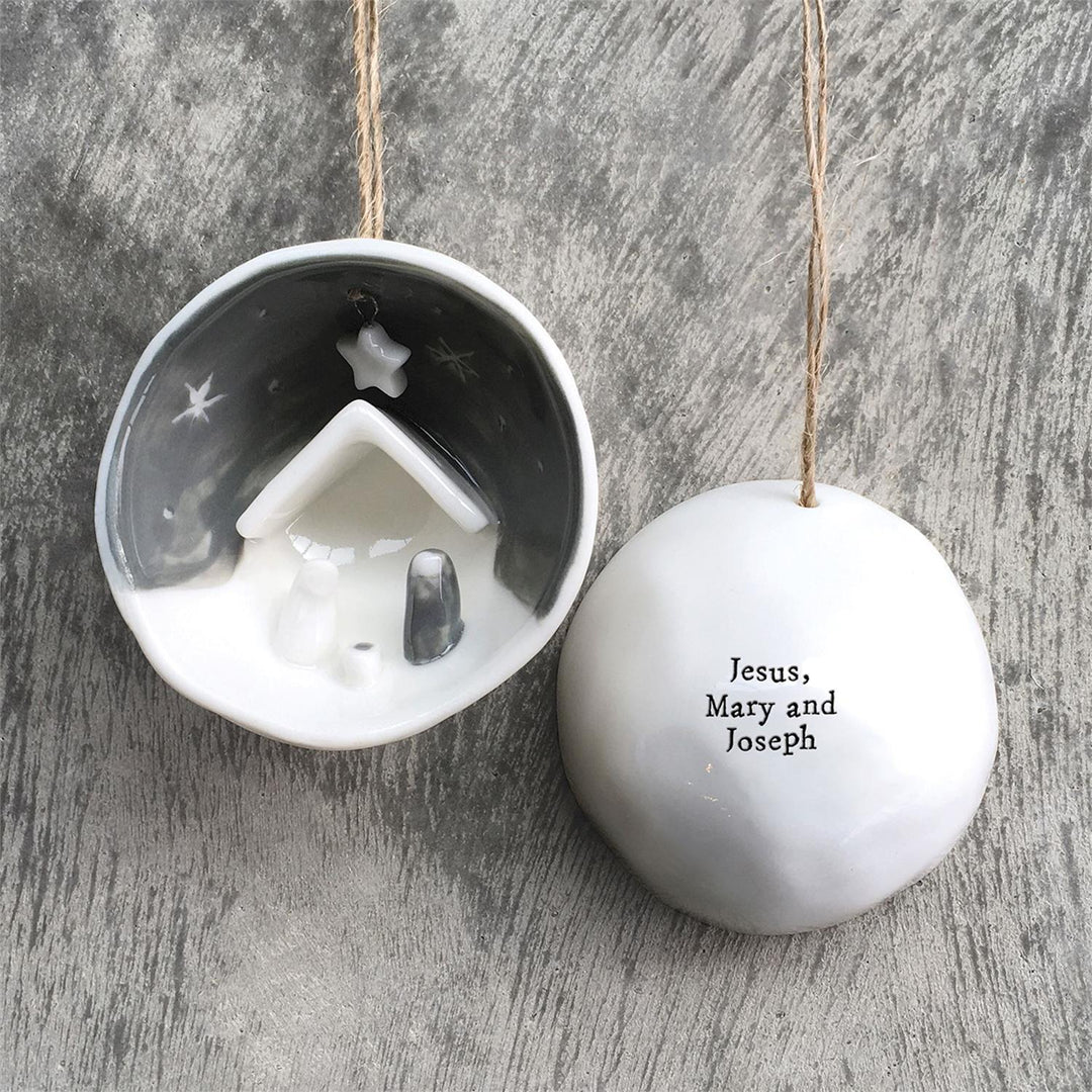 Nativity half-circle porcelain ornament in gift box, featuring a nativity scene and “Jesus, Mary and Joseph” text.