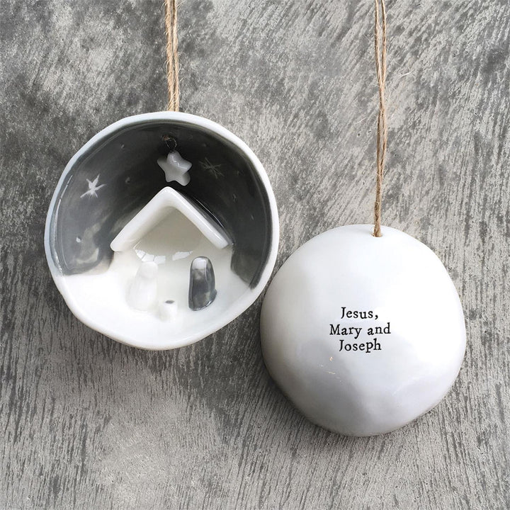 Nativity half-circle porcelain ornament in gift box, featuring a nativity scene and “Jesus, Mary and Joseph” text.