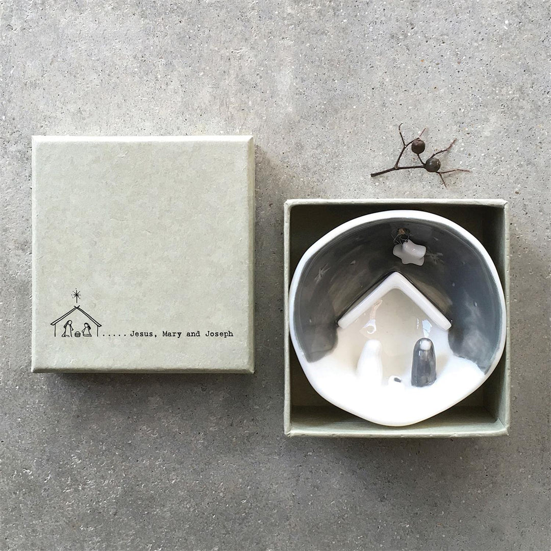 Nativity half-circle porcelain ornament in a square gift box, featuring “Jesus, Mary and Joseph” text and line-art illustration.