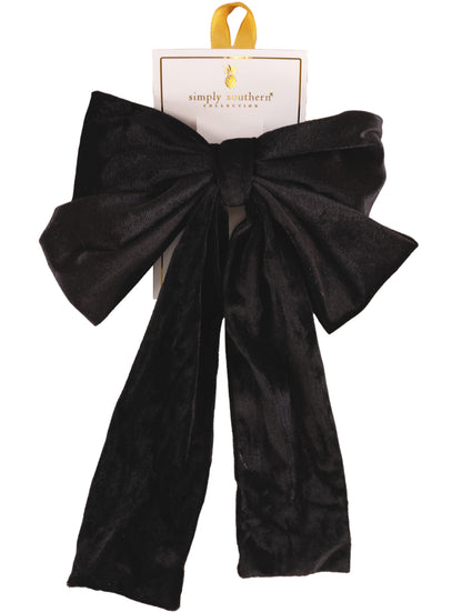 Large black velvet bow hair accessory with long tails; available in one size.