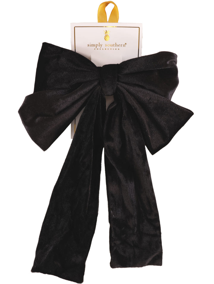 Large black velvet bow hair accessory with long tails; available in one size.