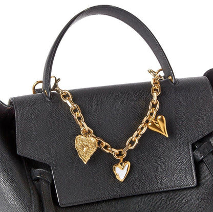 Charmed Life Chain Bag Charms: gold chain with three charms—gold heart, white heart, gold lion head heart. Available in small and large sizes.