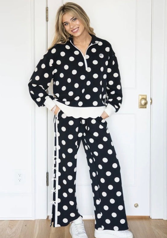 Black wide-leg lounge pants with large white polka dots and white cuffs. Available in sizes XS-XL.